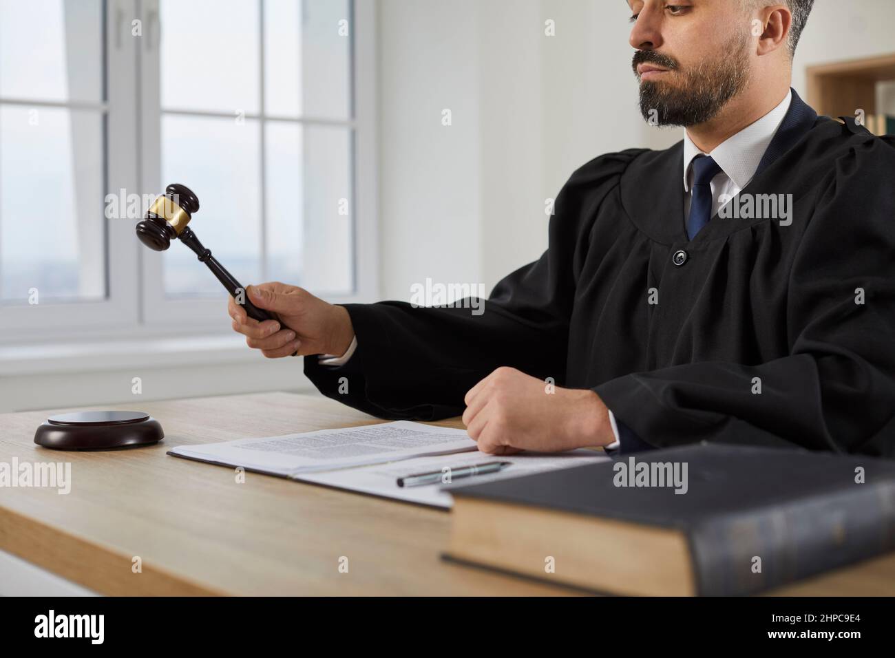 Giudice maschio che batte il gavel e che dà il suo giudizio alla fine del processo di corte Foto Stock
