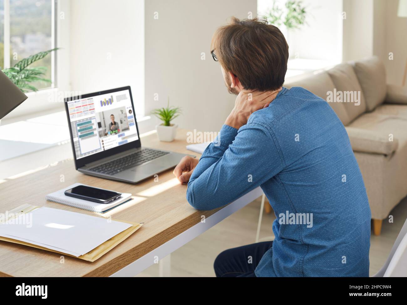 Il lavoro dell'uomo sul computer soffre di dolore al collo Foto Stock