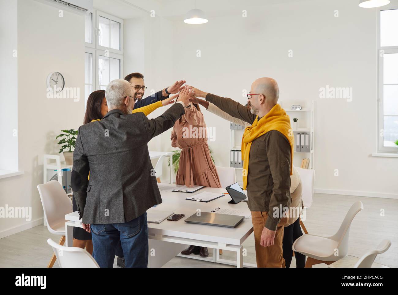 I dipendenti motivati si uniscono per celebrare il successo condiviso Foto Stock