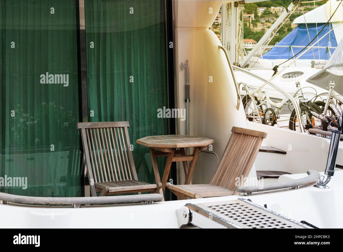 Tavolo e sedie in legno per un soggiorno confortevole su uno yacht sulla costa del mare. Area lounge su uno yacht. Gita in barca. Foto Stock