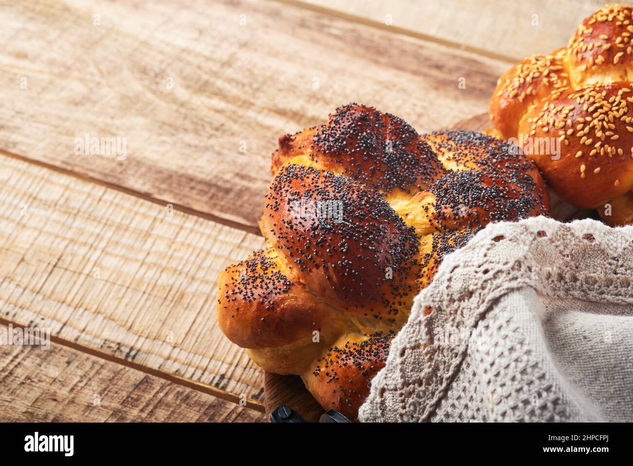 Shabbat Shalom. Sfida del pane con semi di sesamo e semi di papavero su sfondo di legno. Pane tradizionale ebraico per Shabbat e Feste. Concep rustico Foto Stock