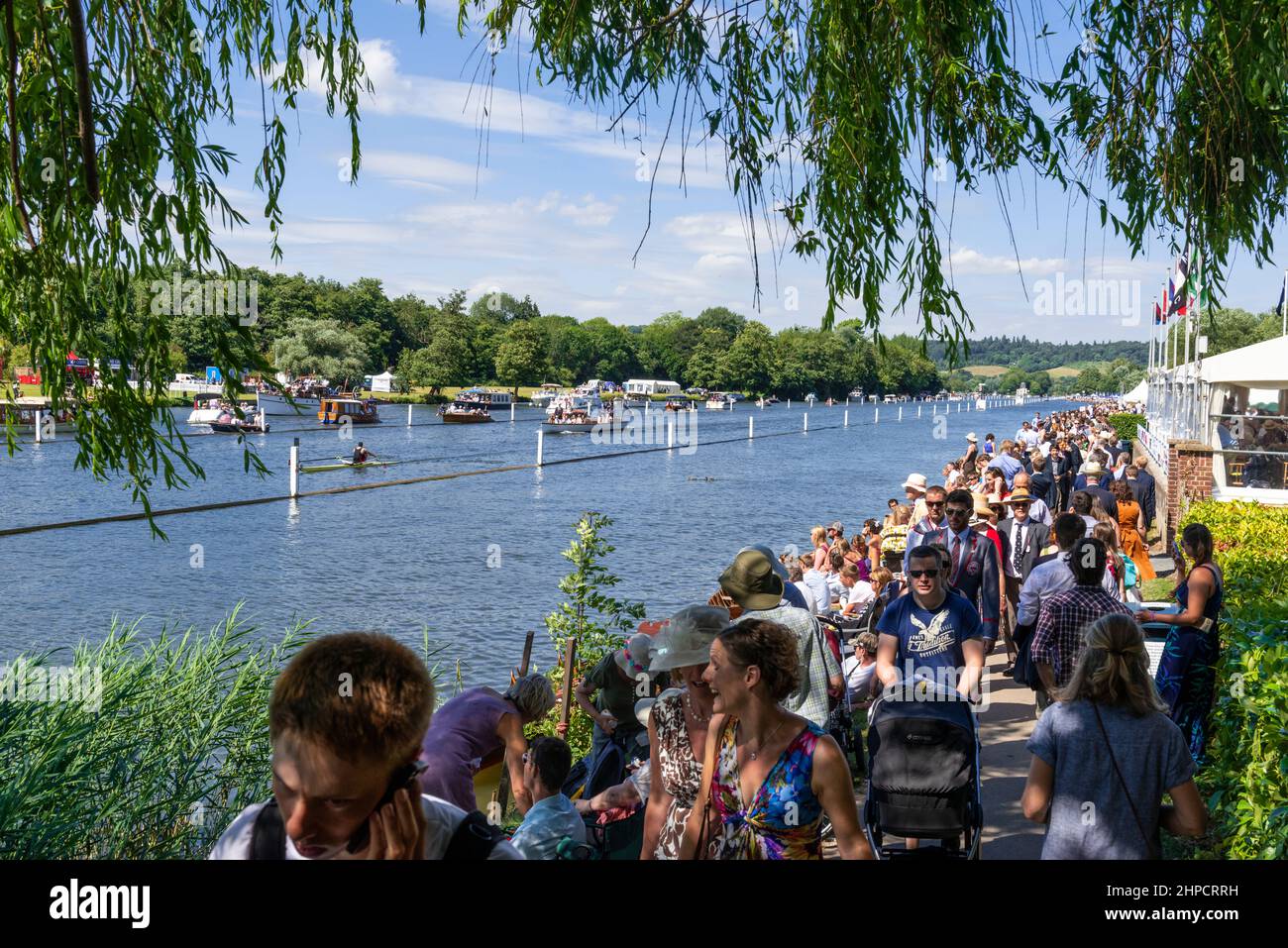 Gli spettatori fiancheggiano l'alzaia e la riva del fiume Tamigi durante la Henley Royal Regatta, parte della stagione sociale britannica, Henley-on-Thames, Inghilterra Foto Stock