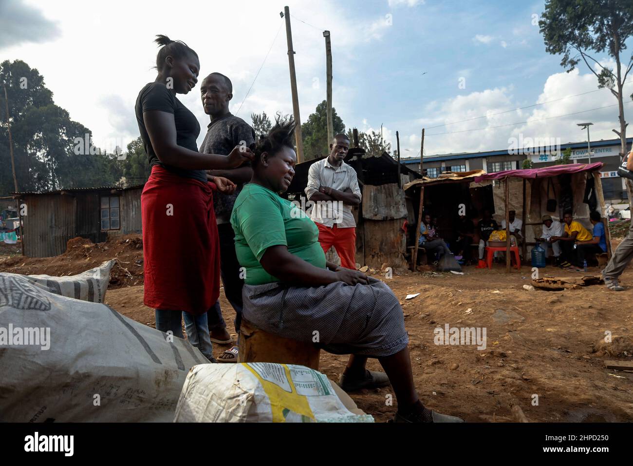 I residenti si scambiano conversazioni fuori dalle loro case nelle baraccopoli di Kibera, Nairobi. All'interno di Kibera Slum, la famigerata casa dove la vita sembra essere sempre di Foto Stock