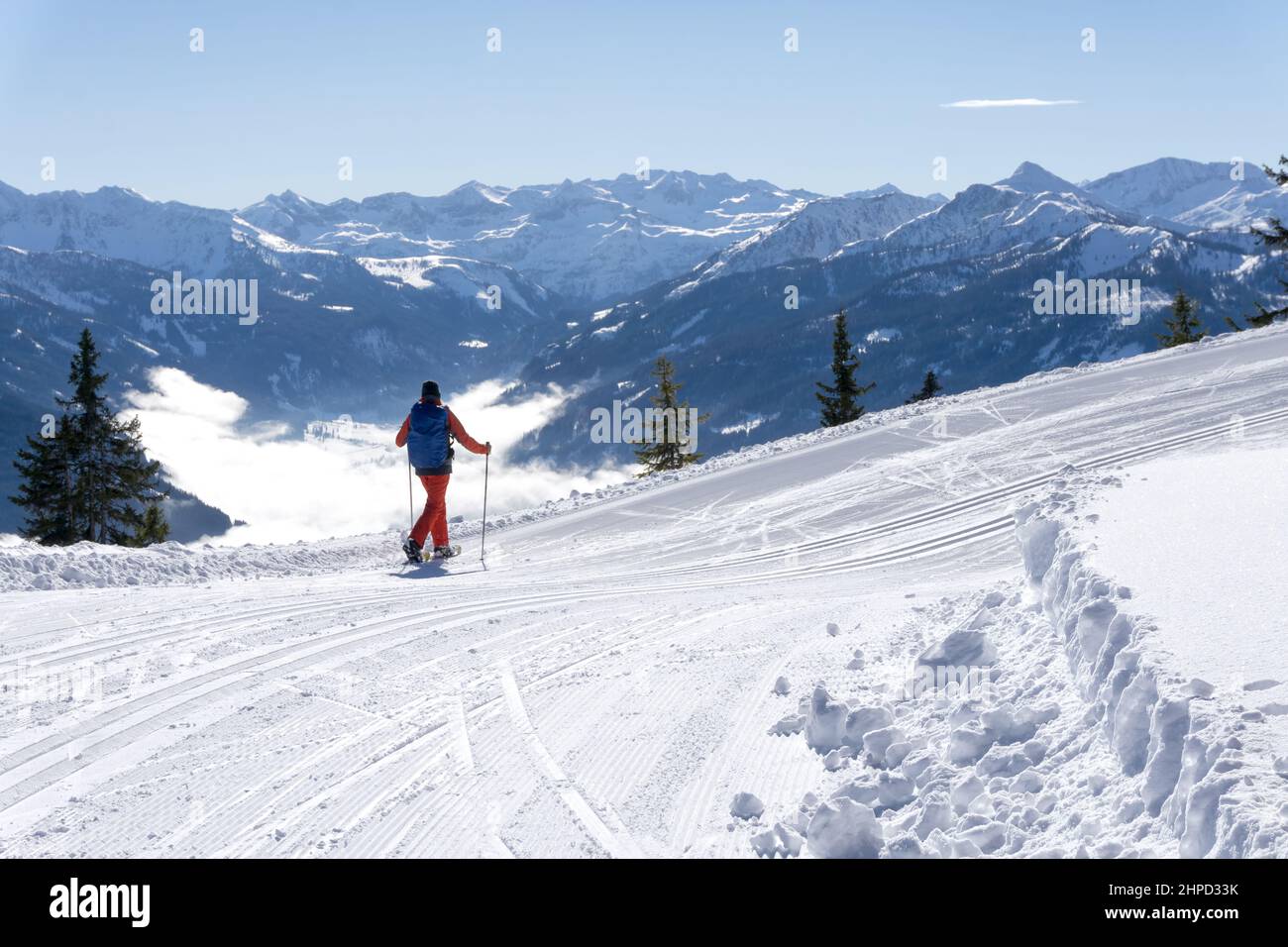 Paesaggio invernale di montagna, Alpi di Salisburgo, Austria, Europa. Un escursionista solitario si aggira intorno alla vetta del Rossbrand con le racchette da neve ammirando la vista panoramica. Foto Stock
