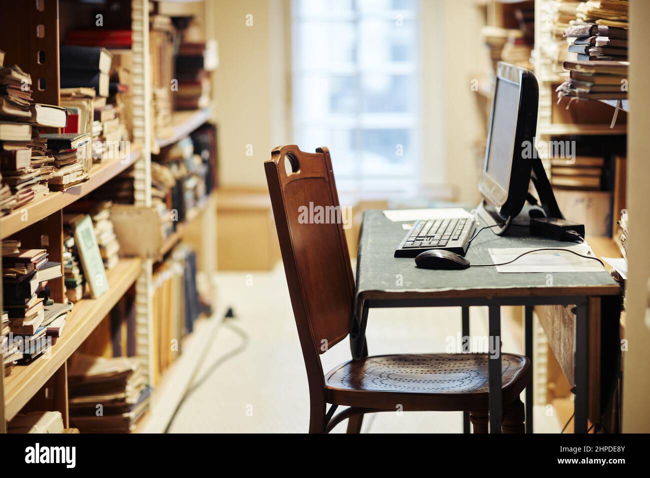 Vista laterale del luogo di lavoro bibliotecario con scaffali in biblioteca pubblica, spazio di copia Foto Stock