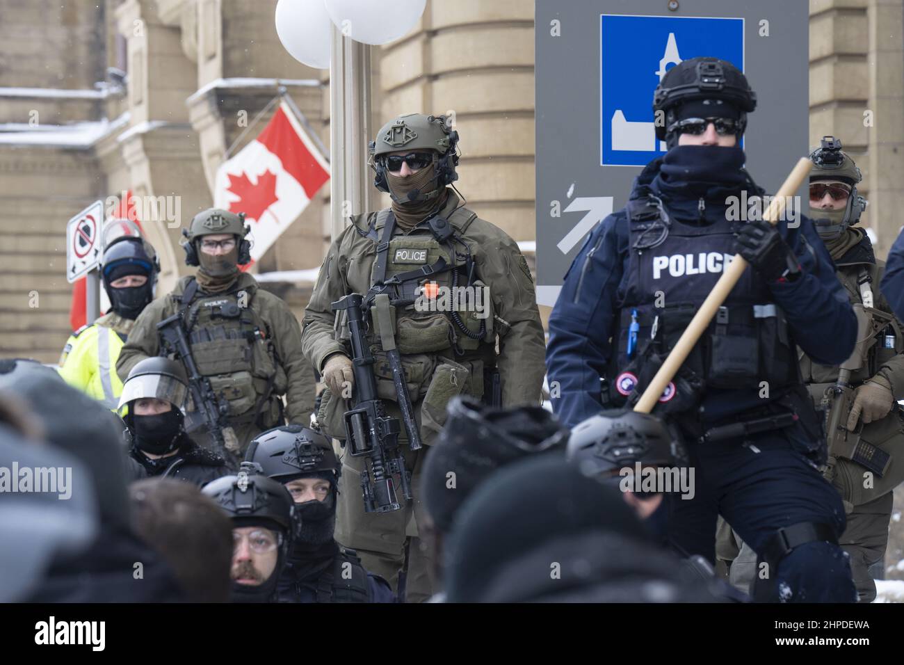 La polizia, tra cui i fucili e i batoni altamente armati RCMP, guida i manifestanti del convoglio Freedom lontano da Parliament Hill a Ottawa, Ontario. Foto Stock