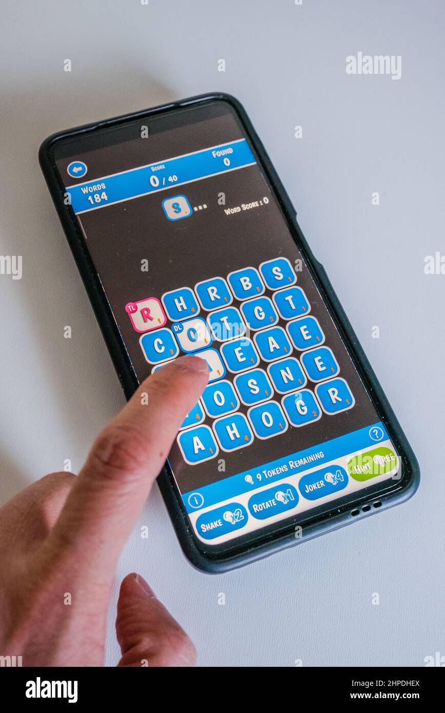 Wortle gioco su uno smartphone con lettere blu e sfondo scuro Foto Stock Wortle gioco su uno smartphone con lettere blu e sfondo scuro Foto Stock