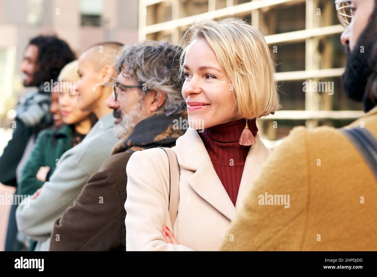 Ritratto di una donna d'affari con potere circondato da colleghi in un ritratto all'aperto. Community e stile di vita. Foto Stock