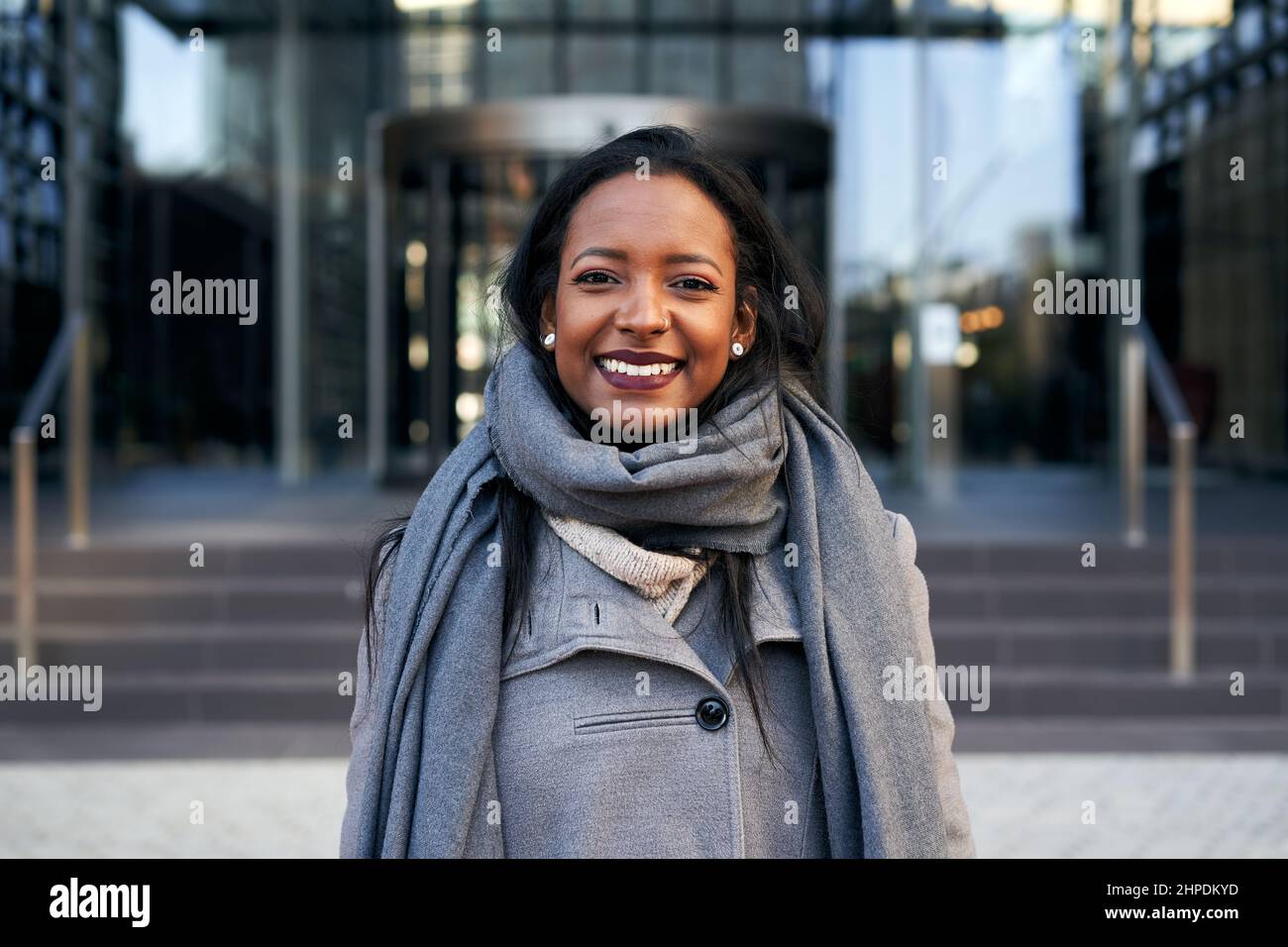 Giovane donna d'affari afroamericana che guarda la macchina fotografica sorridente. Signora allegra sorridente per i successi del lavoro. Foto Stock