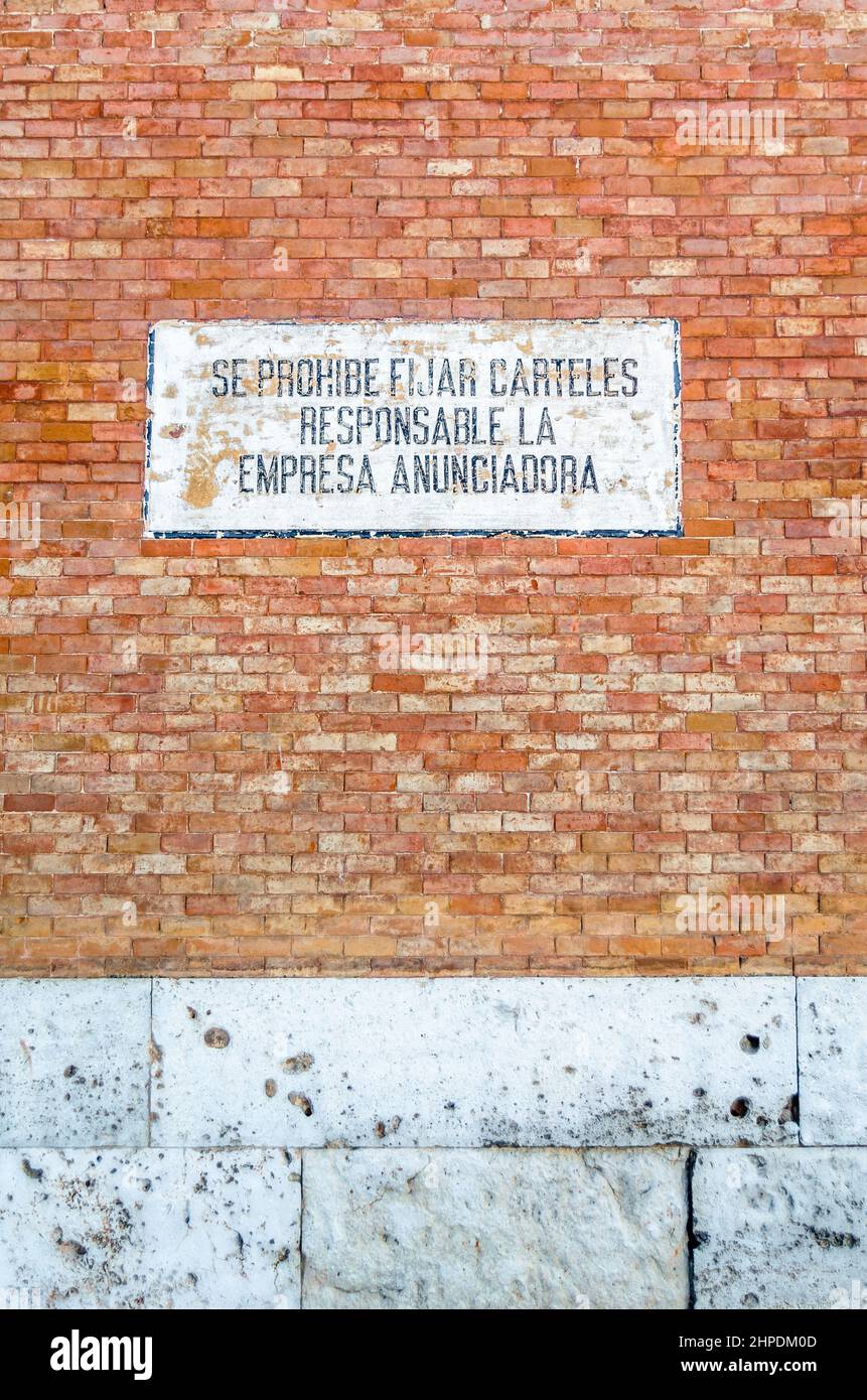 Vecchio segno su un muro, che vieta di mettere i poster. Il testo in spagnolo dice: "È vietato l'invio di cartelli. Responsabile è la società pubblicitaria Foto Stock
