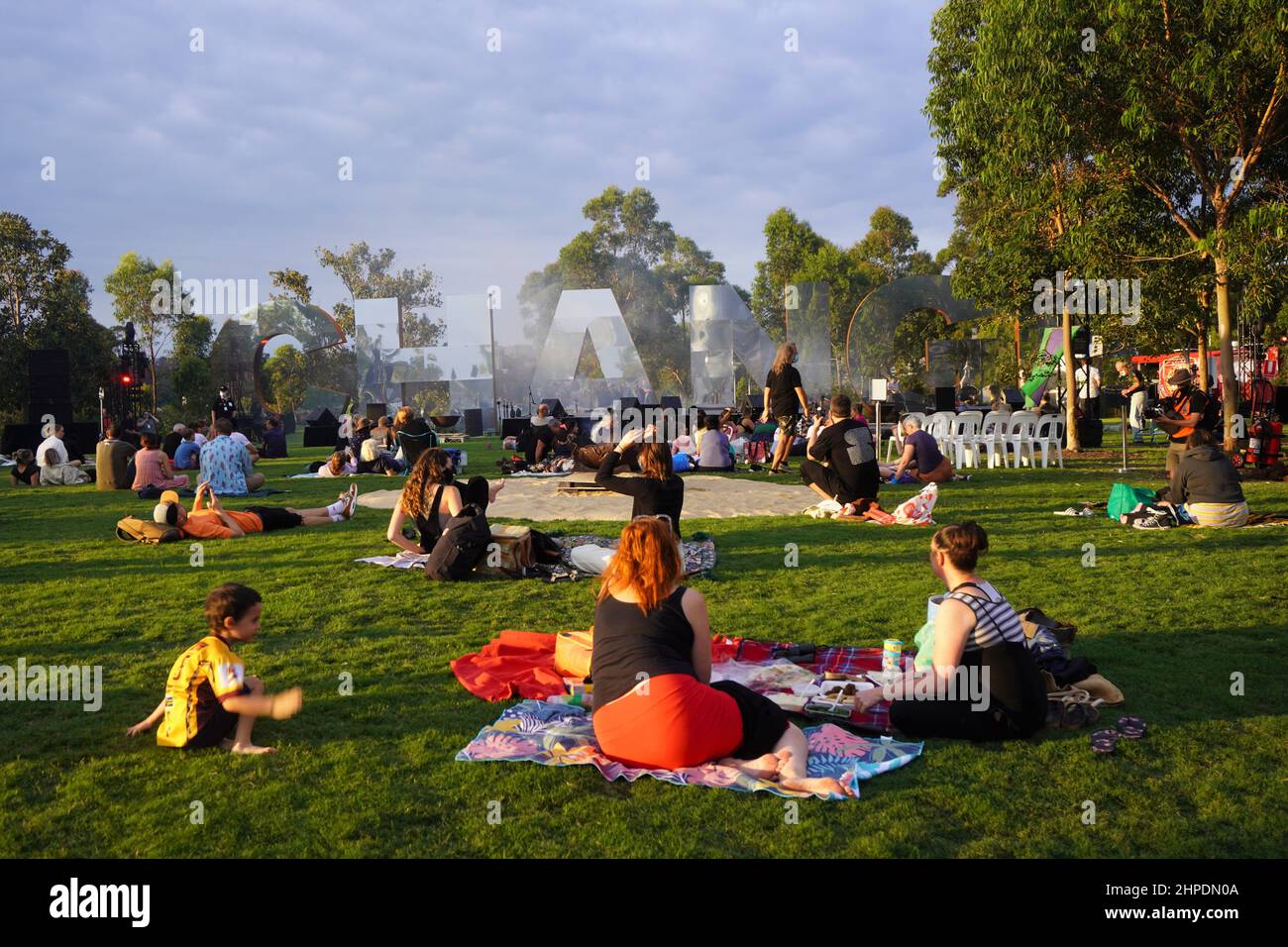 Open Air Concert Goers picnic su un prato alla luce del tardo pomeriggio Foto Stock