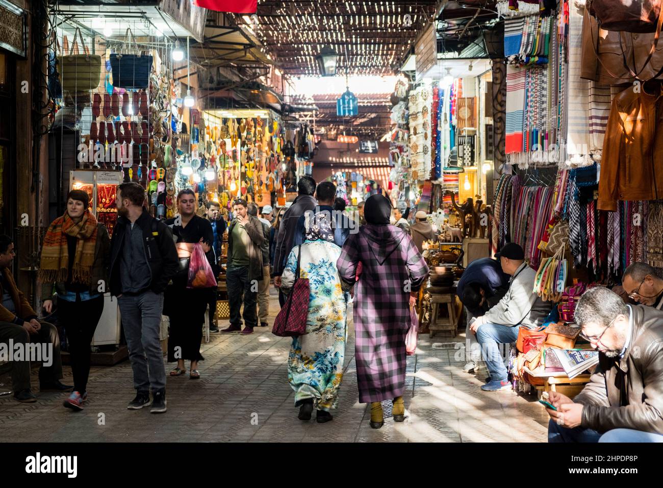 I turisti e la gente del posto navigano attraverso le strade trafficate della Medina, Marrakech, Marocco Foto Stock