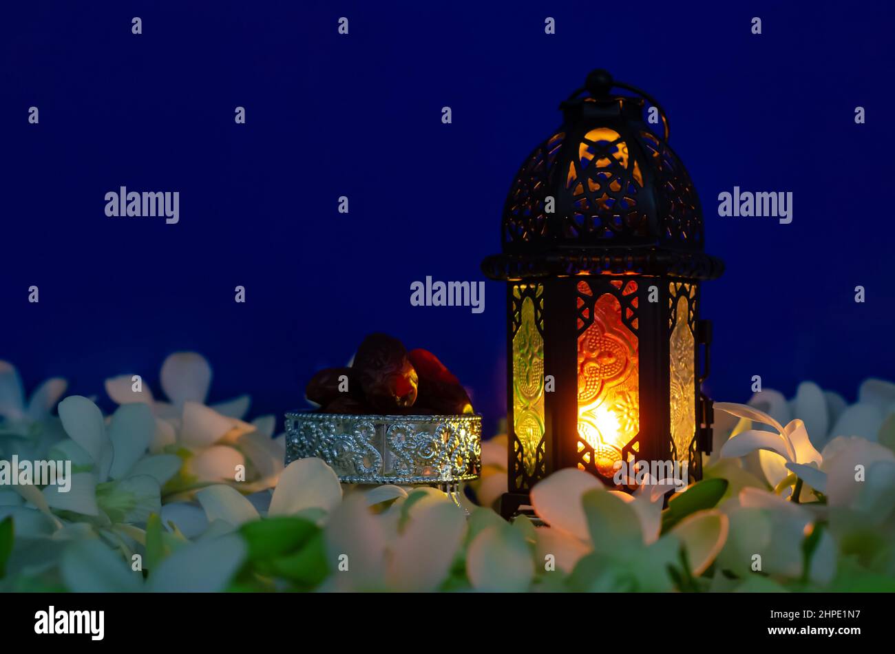 Lanterna su sfondo blu con datteri frutta su fiore di orchidea per la festa musulmana del mese santo di Ramadan Kareem. Foto Stock