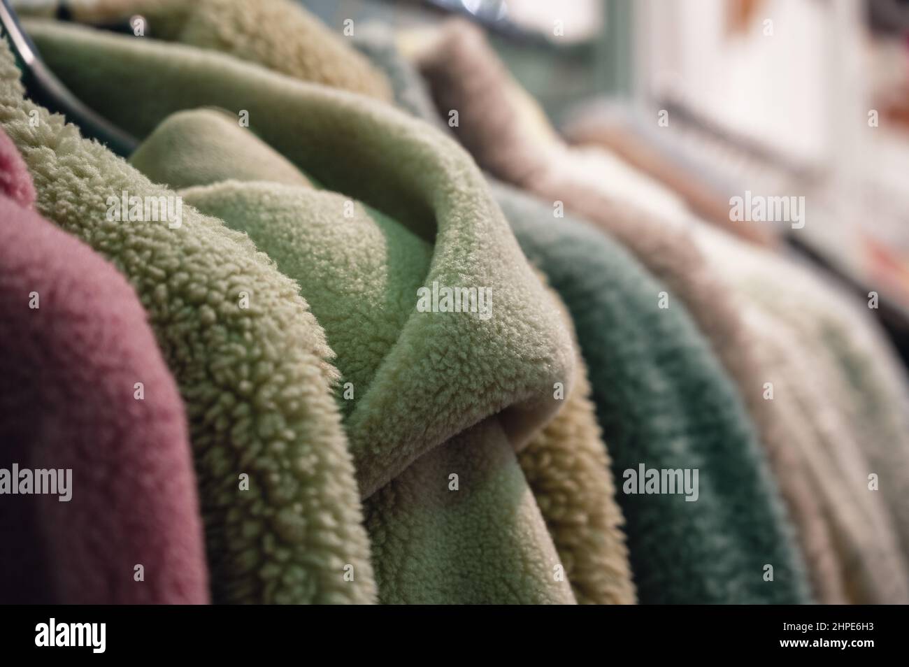 Eleganti cappotti e giacche in pelliccia sintetica appendono sul rack Foto Stock