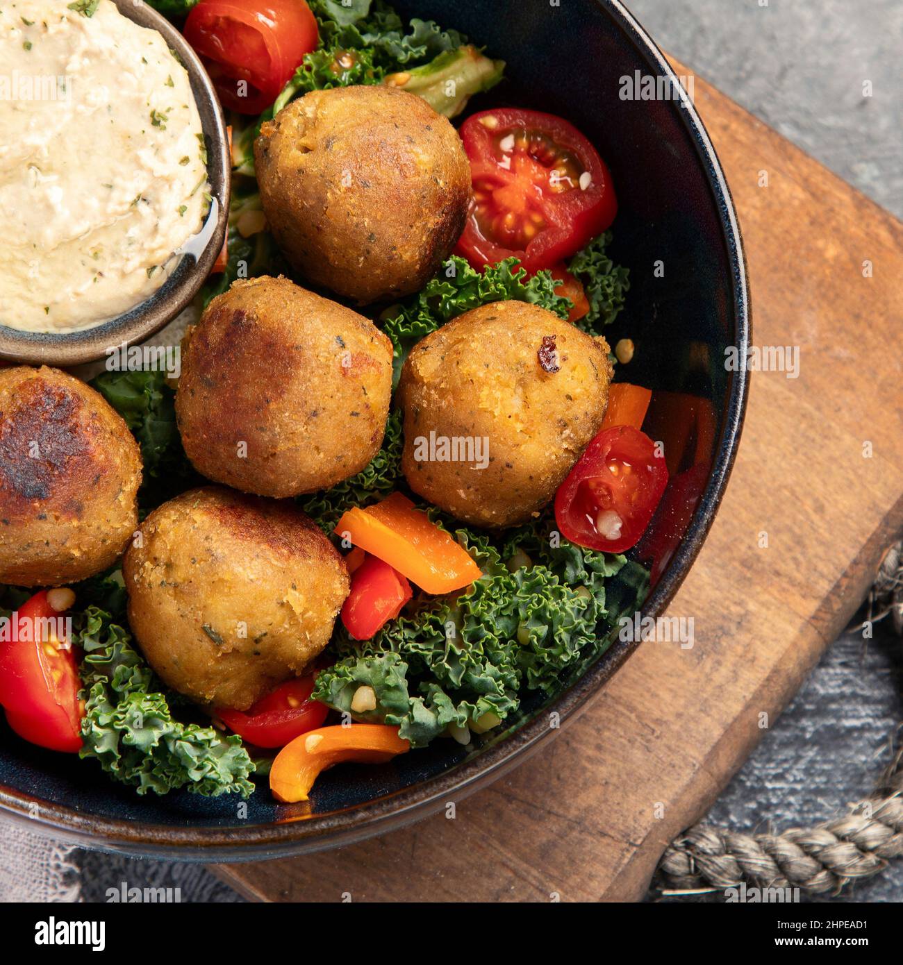 Falafel con hummus su sfondo scuro. Concetto di dieta mediterranea. Disposizione piatta, vista dall'alto, spazio di copia Foto Stock