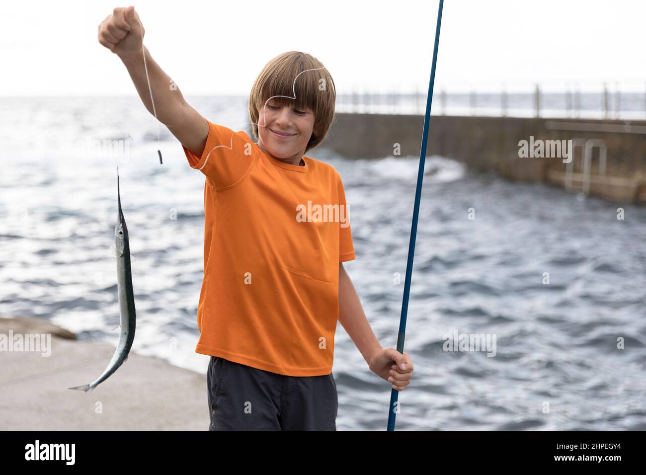 Ragazzo che mostra pesce catturato, Terceira, Azzorre, Portogallo Foto Stock
