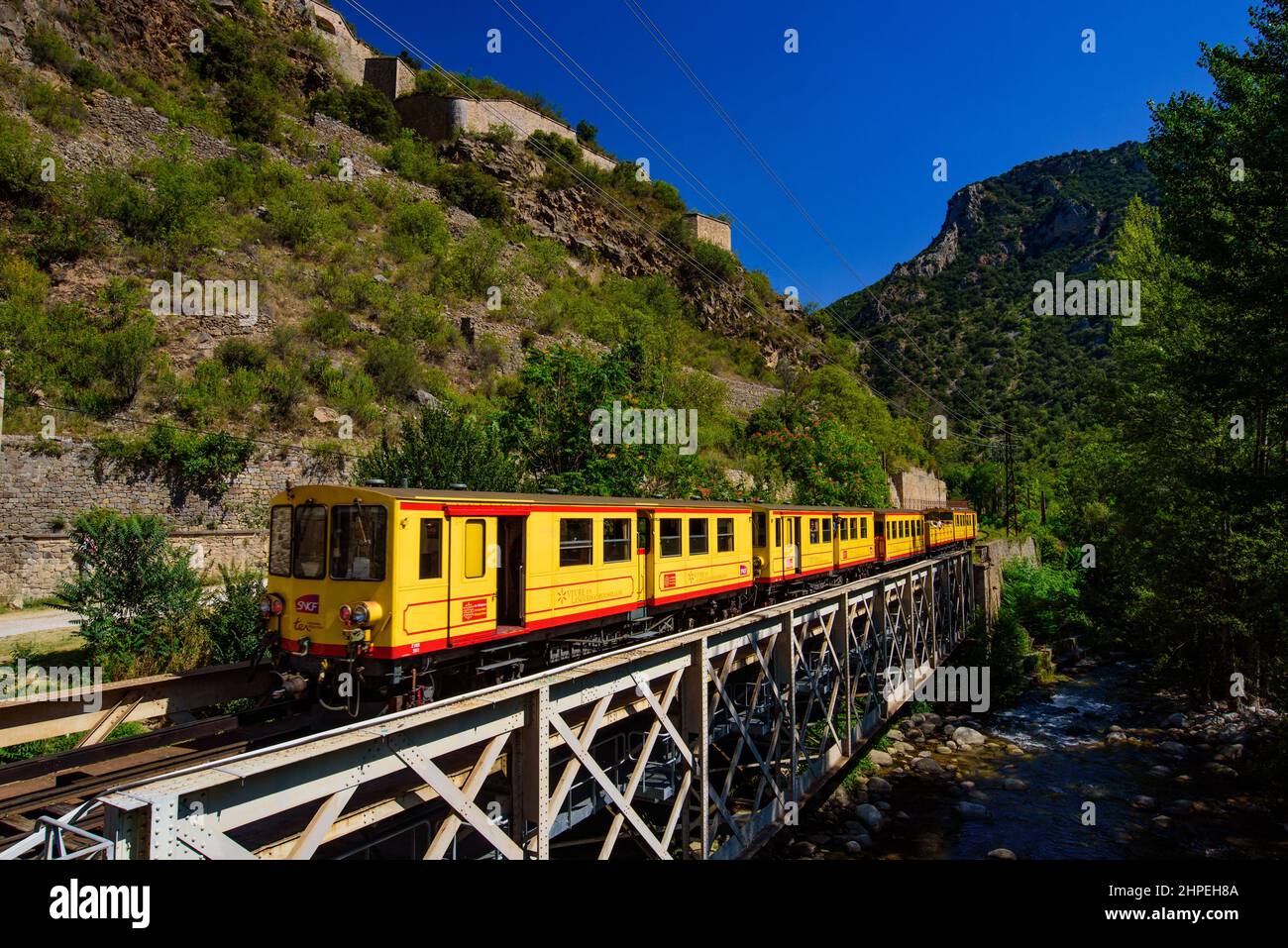 Il piccolo treno giallo (le Petit treno Jaune) passando per Villefranche-de-Conflent, Francia Foto Stock