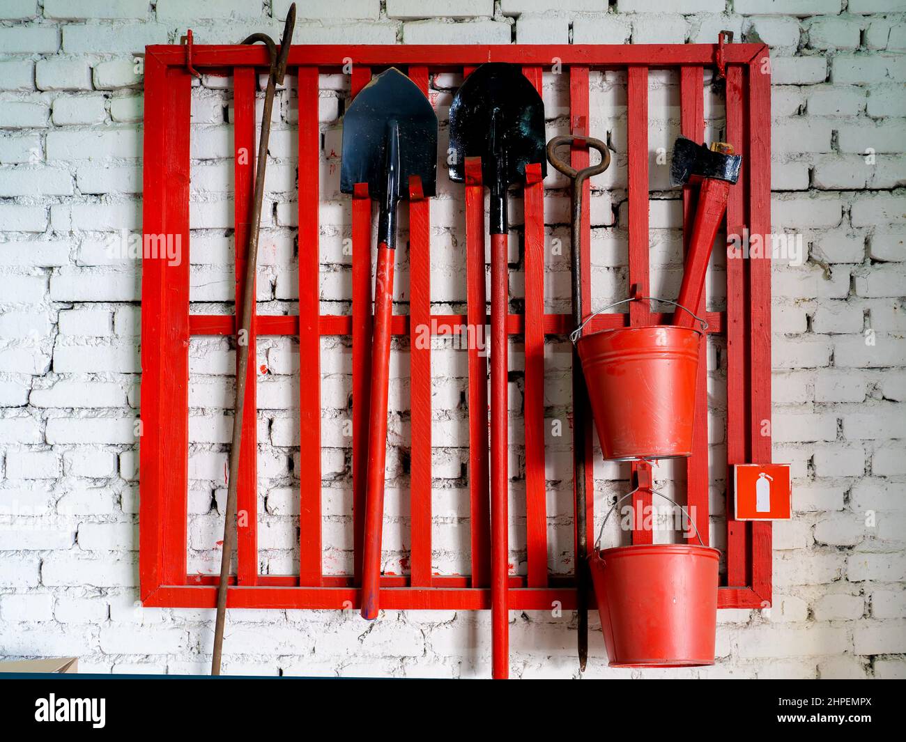 Montato a parete di protezione antincendio con sistema antincendio strumenti. La pala, gancio , ax, cono benna, estintore e di altre attrezzature impiccati sul punto di fuoco. Foto Stock
