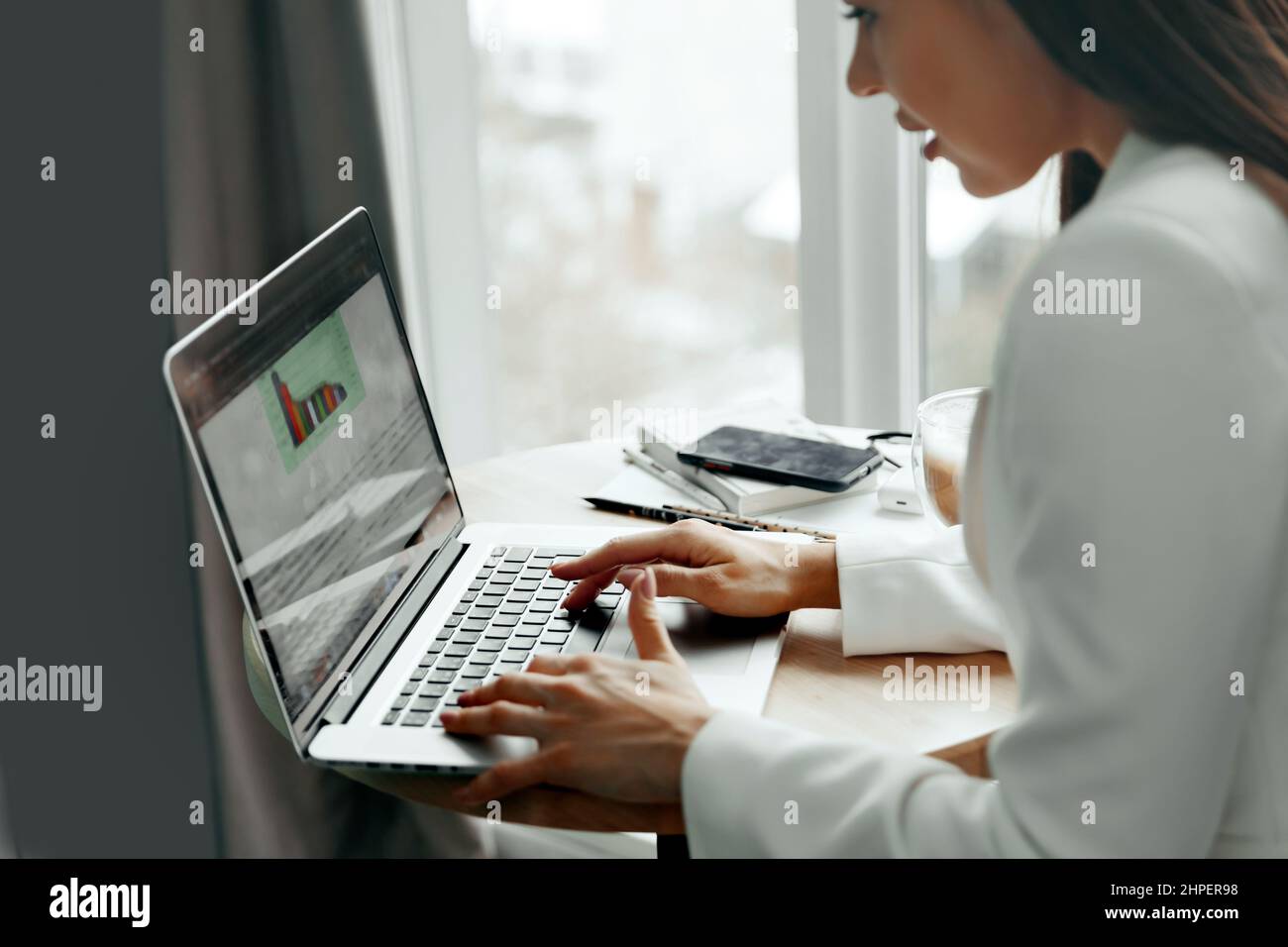 Donna d'affari che lavora su un computer portatile che gestisce la sua attività in ufficio Foto Stock