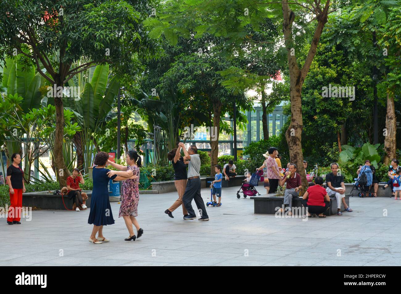 Anziani cinesi socializzare in un parco aperto. Questa scena a Shenzhen, in Cina, è una vista comune ogni giorno, con la gente che balla e firma. Foto Stock
