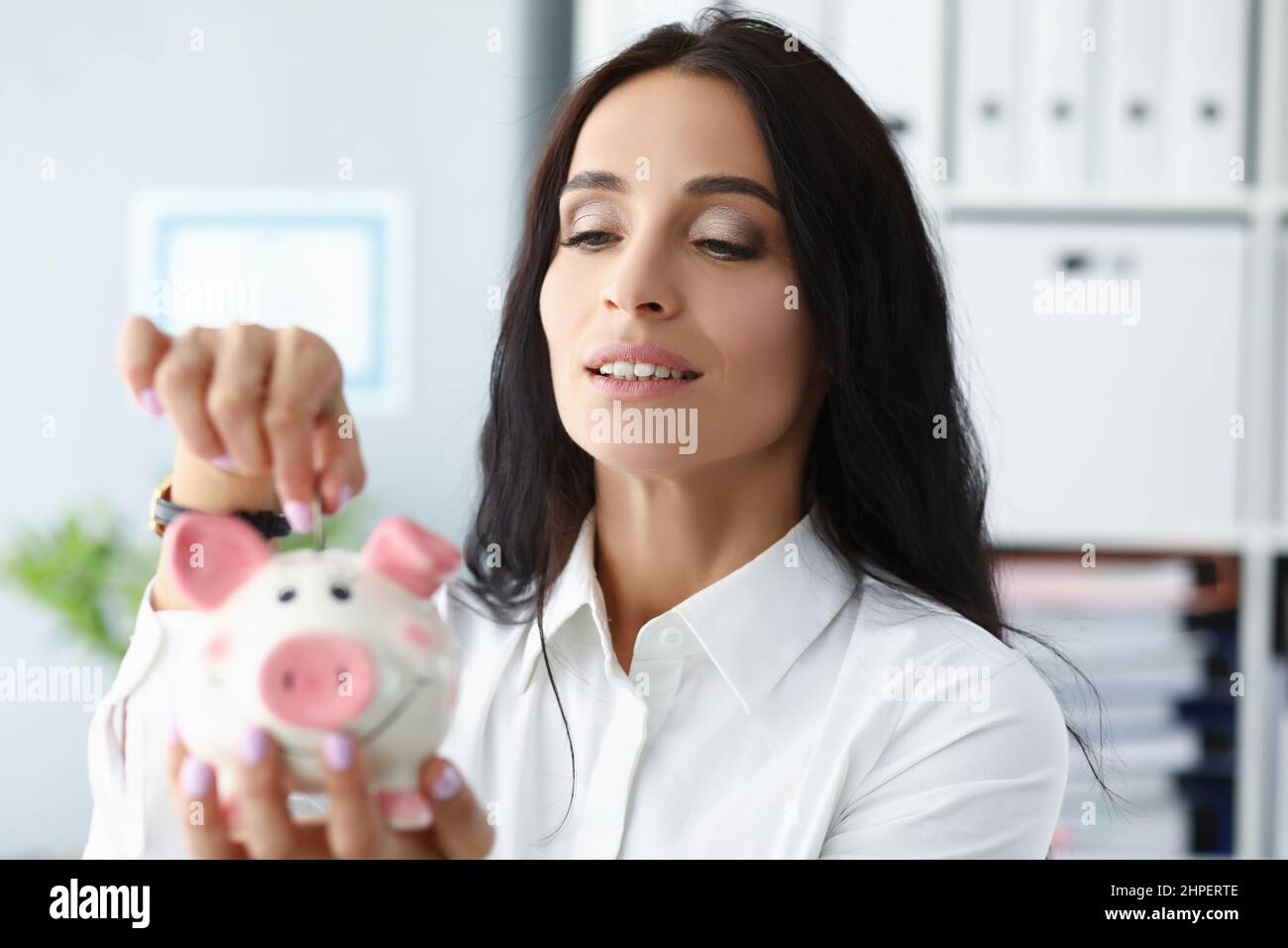 Bella donna mettere moneta in contenitore piggybank, lavoratore risparmiare denaro, raccogliere contanti Foto Stock