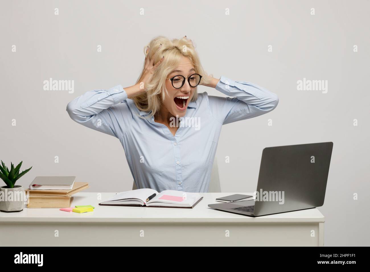 Aumento dei salari. Un'operatrice in ufficio molto gioiosa che guarda lo schermo del laptop con entusiasmo, felice dopo l'aumento dello stipendio Foto Stock
