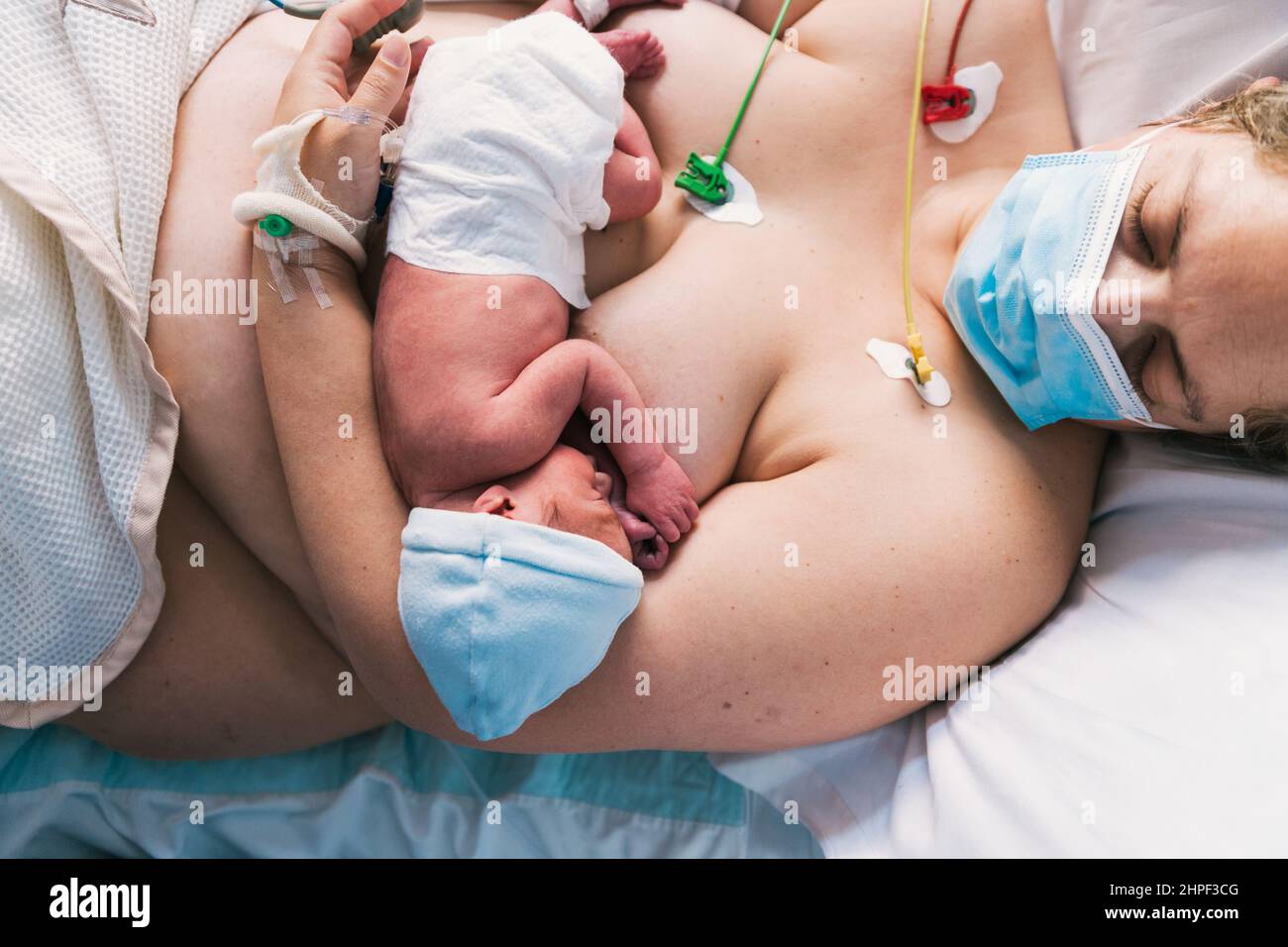 Madre che tiene il suo neonato dopo il parto nella sala parto dell'ospedale. Foto Stock