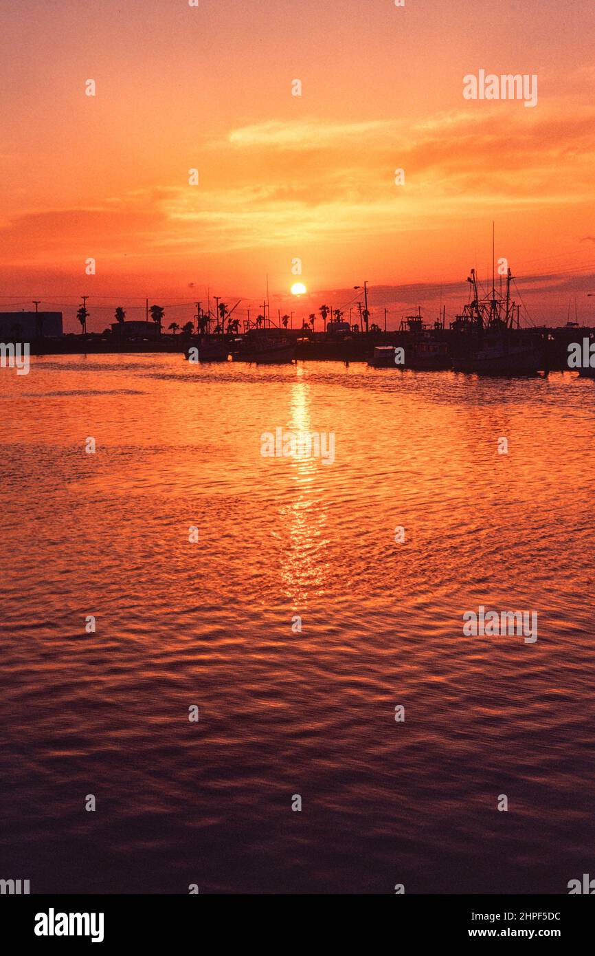 Barche in silhouette all'alba sull'isola di Mustang, Port Aransas, Texas. Foto Stock