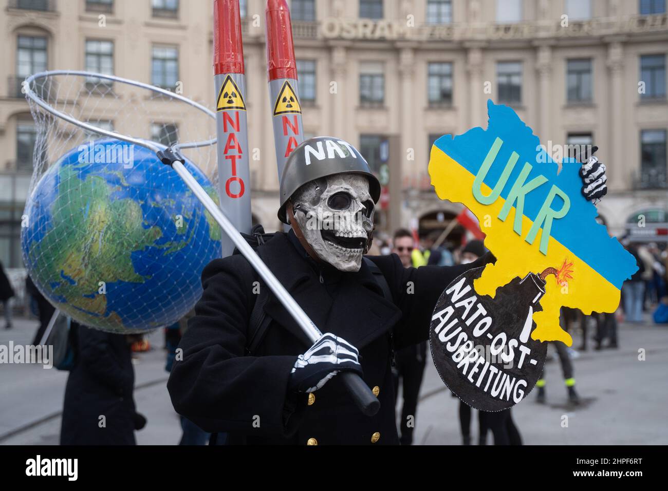 Monaco di Baviera, Germania. 19th Feb 2022. Partecipante con segno „Ukr NATO est expansion“, cranio e rete con la terra in esso. Il 19 febbraio 2022, migliaia di partecipanti si sono riuniti per manifestare contro la Conferenza sulla sicurezza di Monaco, contro la guerra e la NATO e per la pace. Quest'anno al MSC, temi come il conflitto Russia-Ucraina vengono affrontati senza la partecipazione della Russia. (Foto di Alexander Pohl/Sipa USA) Credit: Sipa USA/Alamy Live News Foto Stock