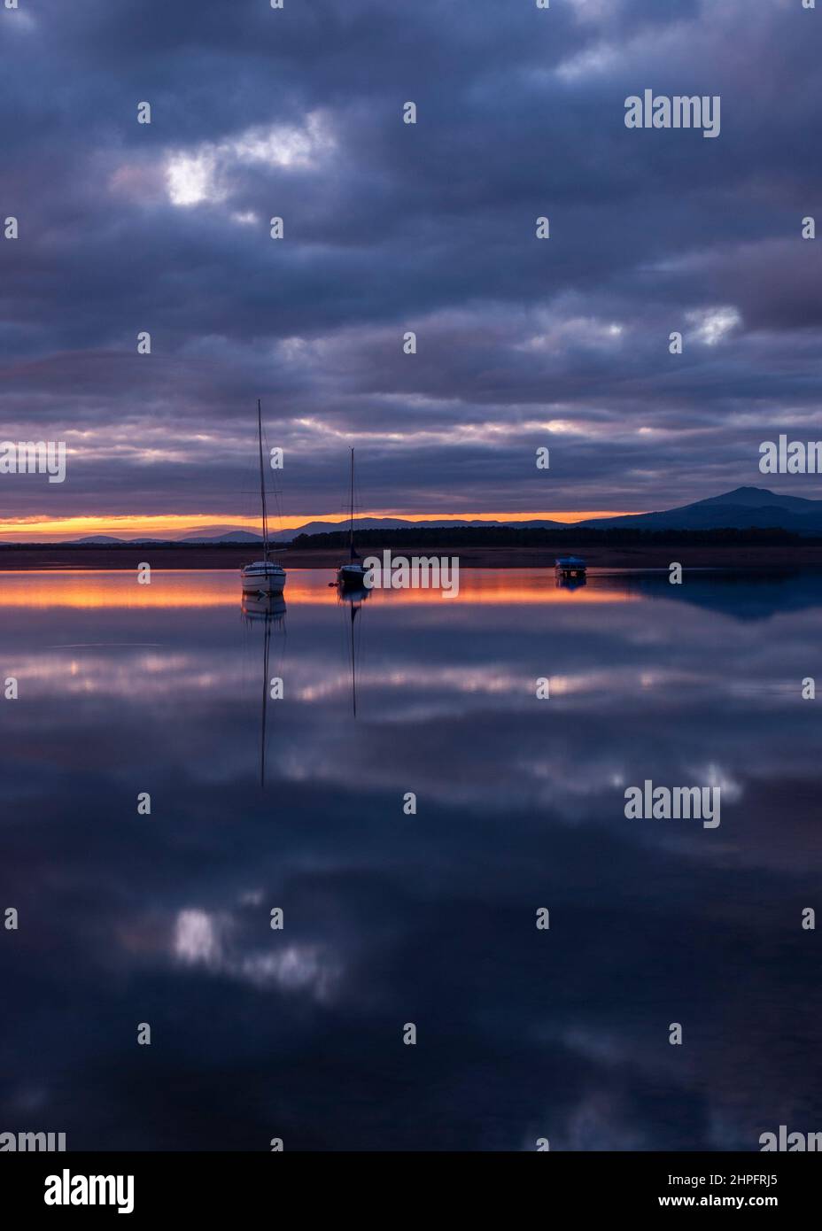 Barche nel serbatoio navigabile di acqua dolce in Estremadura, Embalse Gabriel y Galan verticalmente al tramonto Foto Stock