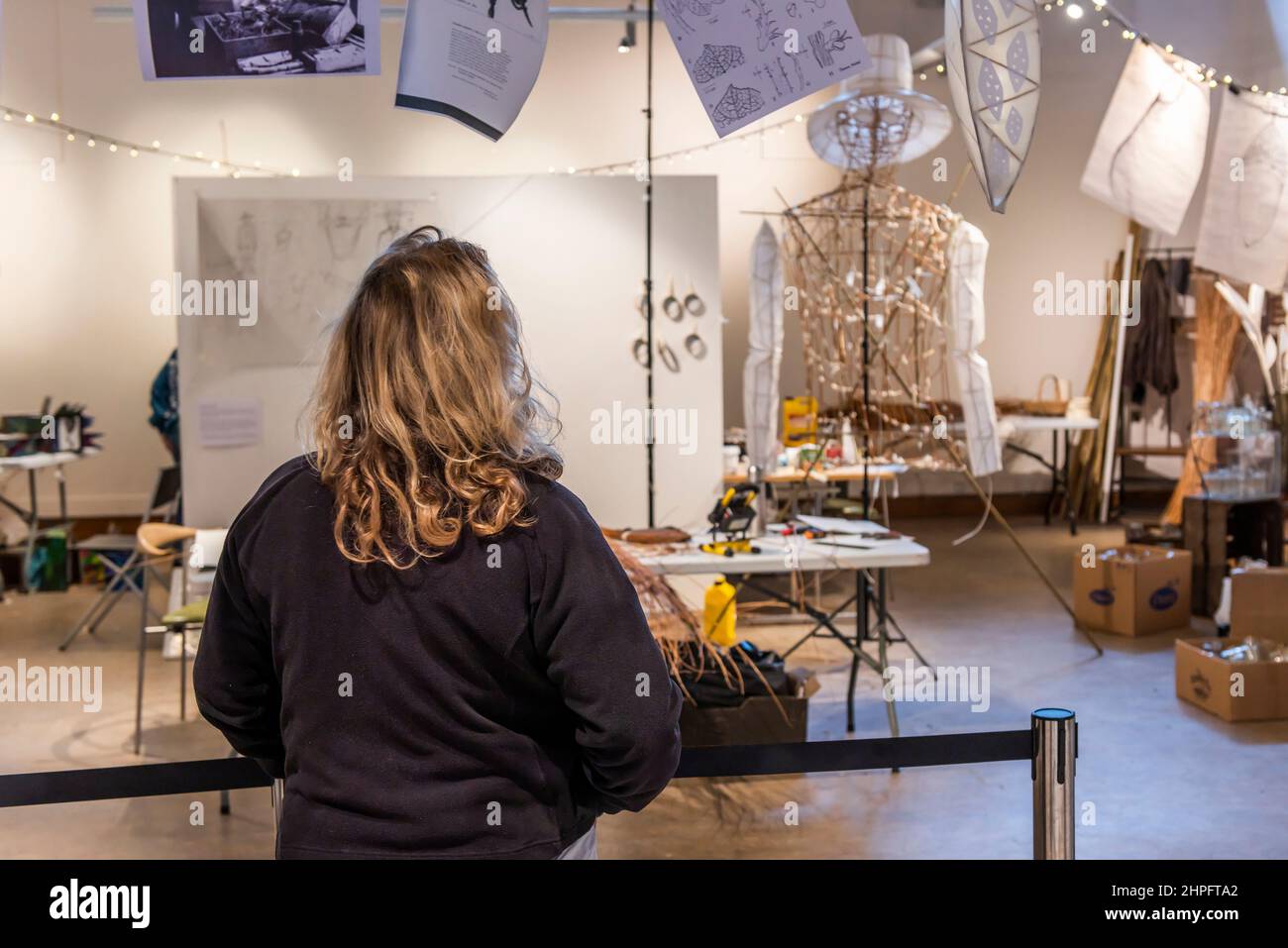 Un membro del pubblico che guarda i progressi della realizzazione delle sculture in preparazione all'evento Trebah Garden of Lights in Cornovaglia. Foto Stock