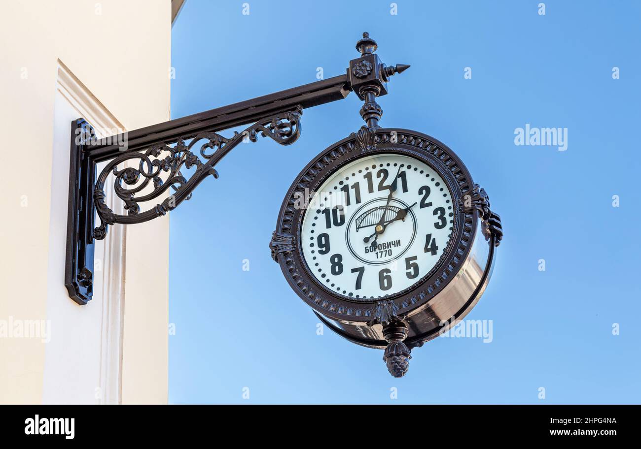 Borovichi, Russia - 29 agosto 2021: Grande orologio decorativo da strada appeso su un muro di costruzione Foto Stock