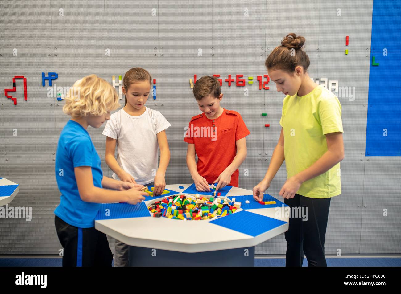 Bambini che giocano con il lego in piedi intorno al tavolo Foto Stock