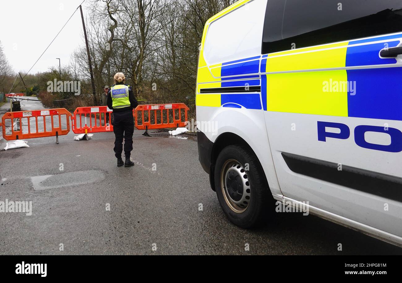 PCSO parla con un uomo, che ha attraversato un'area di non ingresso dove i cavi elettrici sono stati portati giù da Storm Franklin a New Mills, Derbyshire. Foto Stock