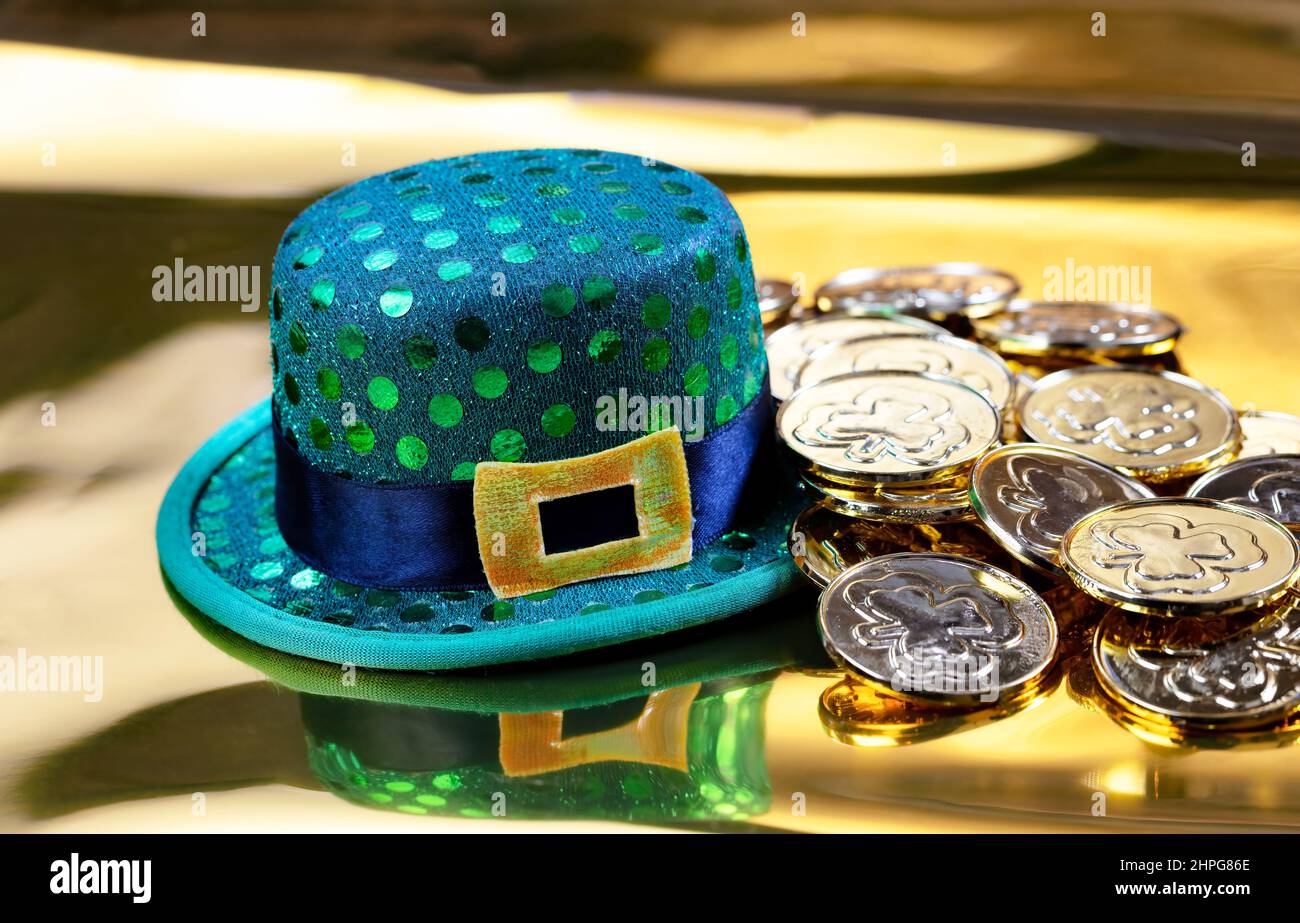 Cappello verde e monete d'oro per San Patrizio su sfondo dorato Foto Stock