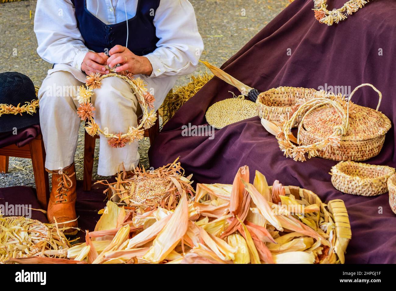 Donna artigiana che fa corone di basketry e fasce di testa da mariti di mais in una fiera artigianale in Galizia Spagna Foto Stock