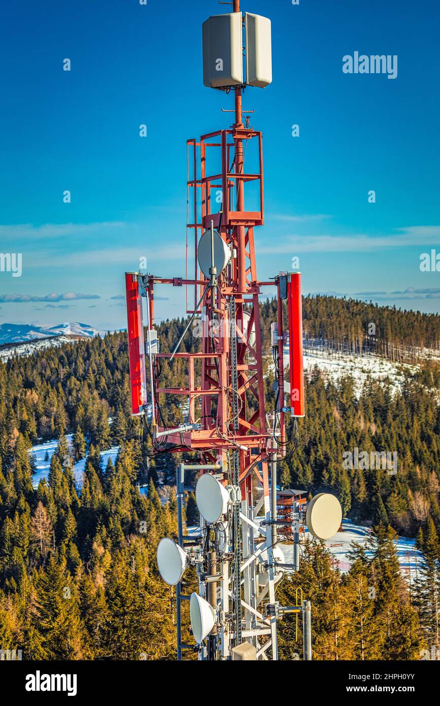 Torre delle telecomunicazioni con antenne in paesaggio montano. Foto Stock