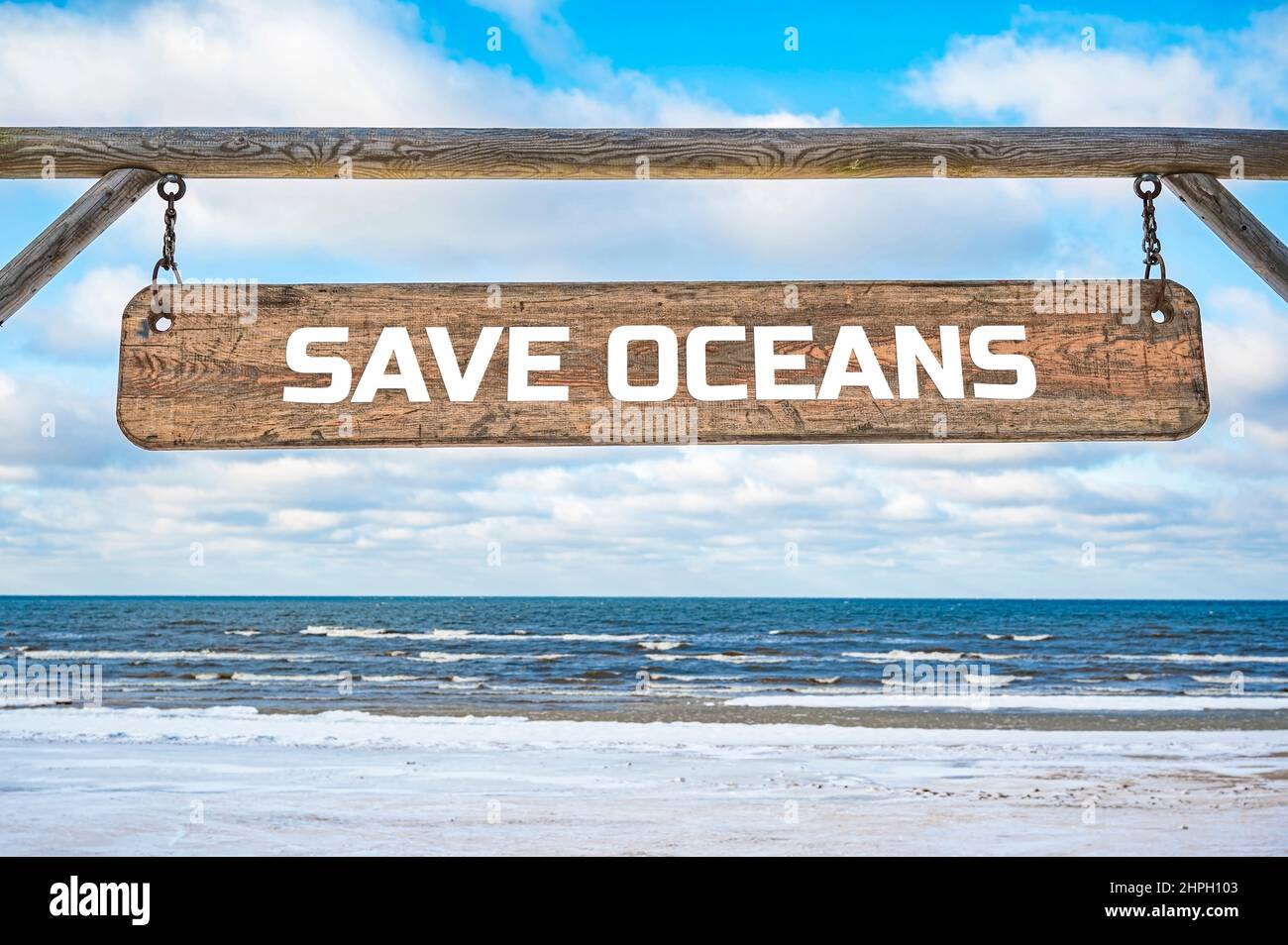 Salva l'insegna in legno degli oceani contro il cielo blu e il mare con le onde sfondo. Foto Stock