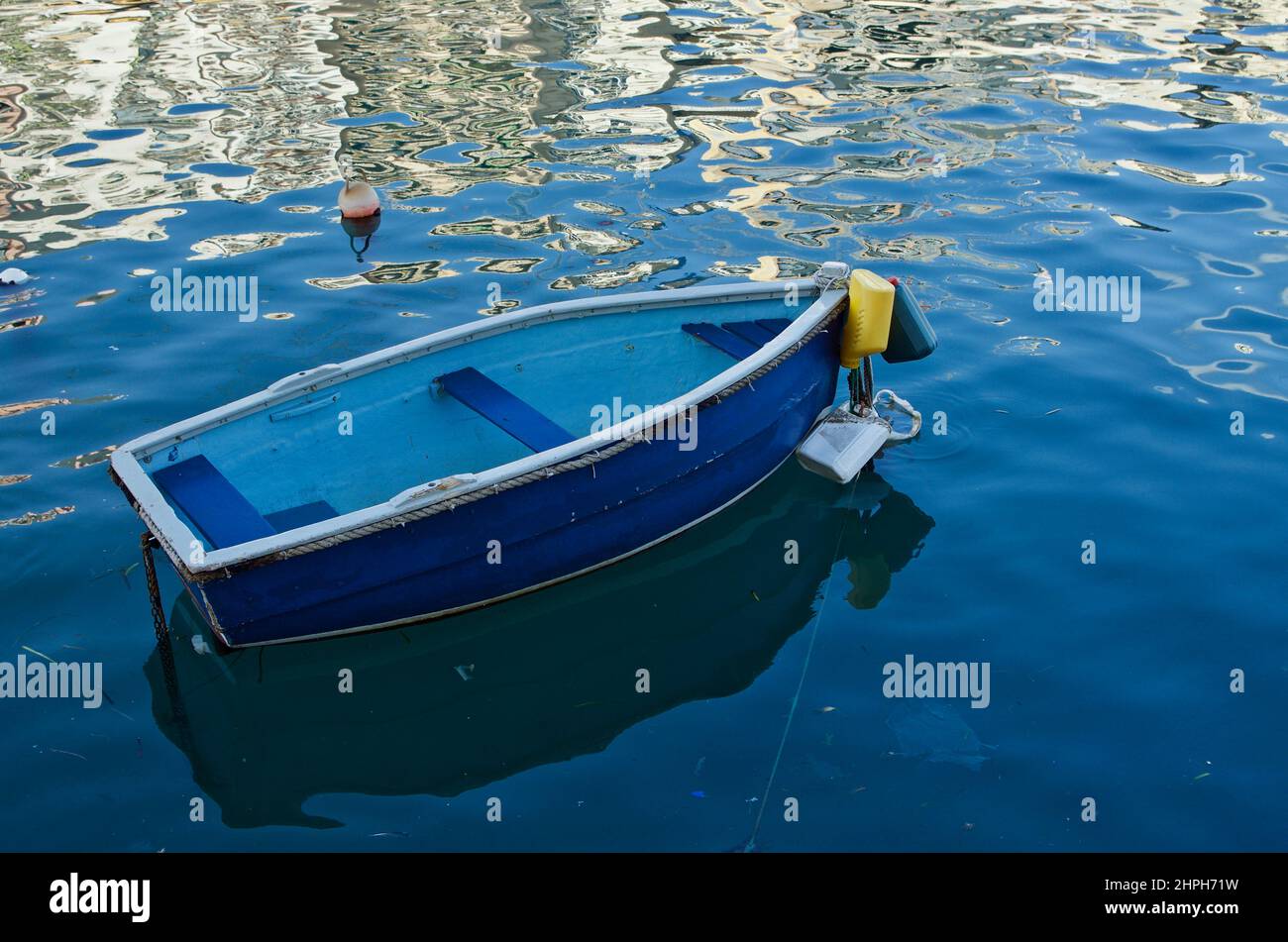 Piccola barca di fronte ai riflessi dell'edificio nell'acqua. Foto Stock