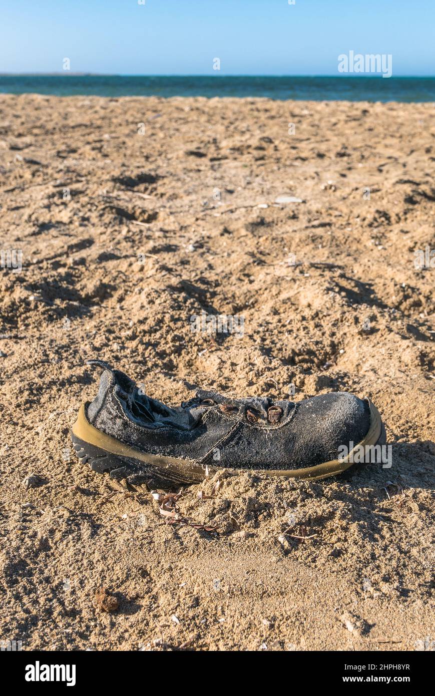 Vecchio, logoro, spazzatura scarpe si è lavato sulla spiaggia di sabbia. Mar Rosso, Egypt Africa Foto Stock