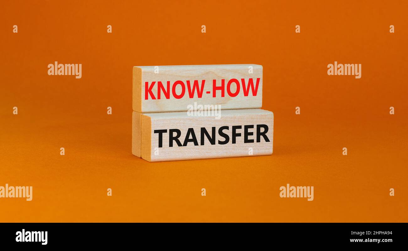 Simbolo di trasferimento del know-how. Concetto parole know-how trasferimento su blocchi di legno su bello arancione tabella sfondo arancione, spazio copia. Business, innovazione Foto Stock