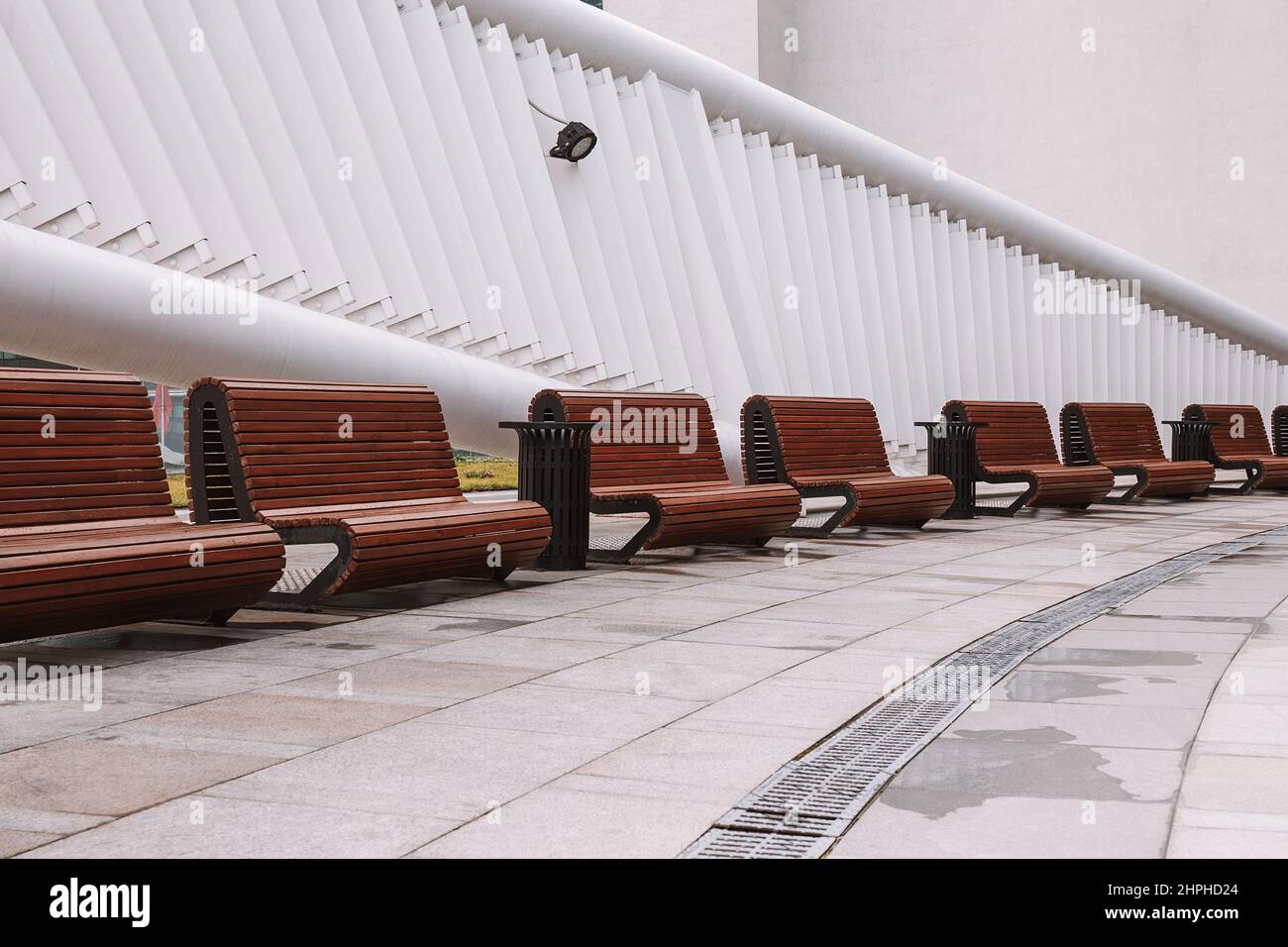 Panchine moderne nella piazza della città. Miglioramento della città, urbanistica, spazi pubblici, design urbano moderno Foto Stock