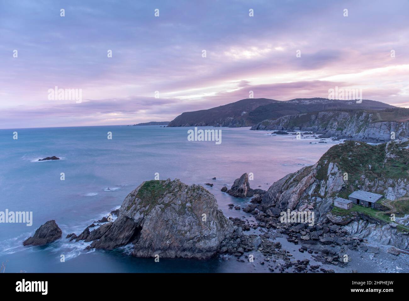 Spettacolare costa atlantica vicino a Cabo Ortegal in Galizia, Spagna, con onde potenti, aspre scogliere vulcaniche e clima nebbioso che creano un oceano selvaggio a. Foto Stock