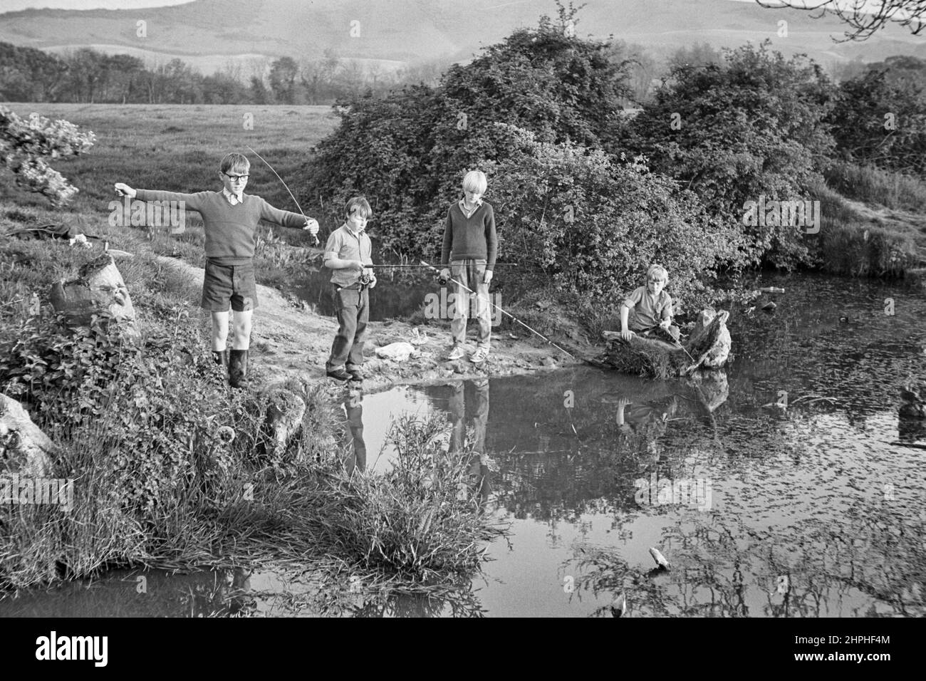 1969 Fotografia di giovani ragazzi che pescano un piccolo laghetto in East Sussex, Inghilterra, Regno Unito. Foto Stock