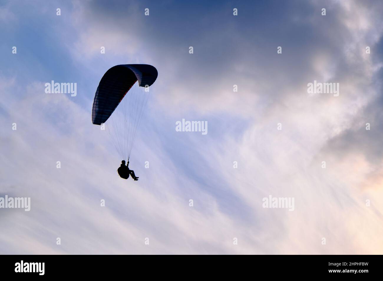 Silhouette in parapendio al tramonto con un bel tocco di luce Foto Stock