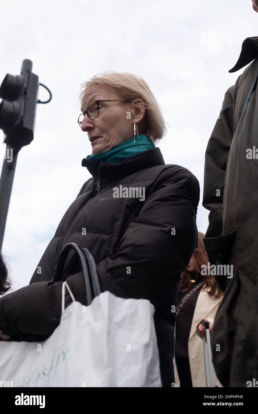 La donna matura attende di attraversare la strada portando una borsa Laura Ashley, Londra UK Foto Stock