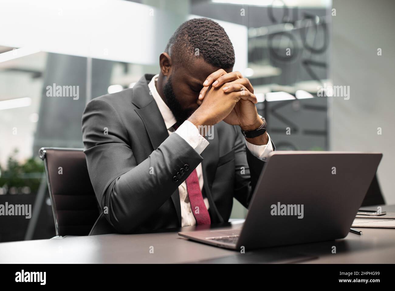 Sconvolto ceo afroamericano seduto di fronte al laptop Foto Stock
