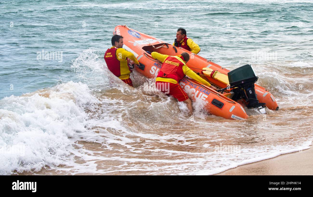 Sydney, New South Wales Australia - Dicembre 26 2021: I salvavita di Mona vale Beach lanciano la loro barca dalla spiaggia e attraverso il surf Foto Stock