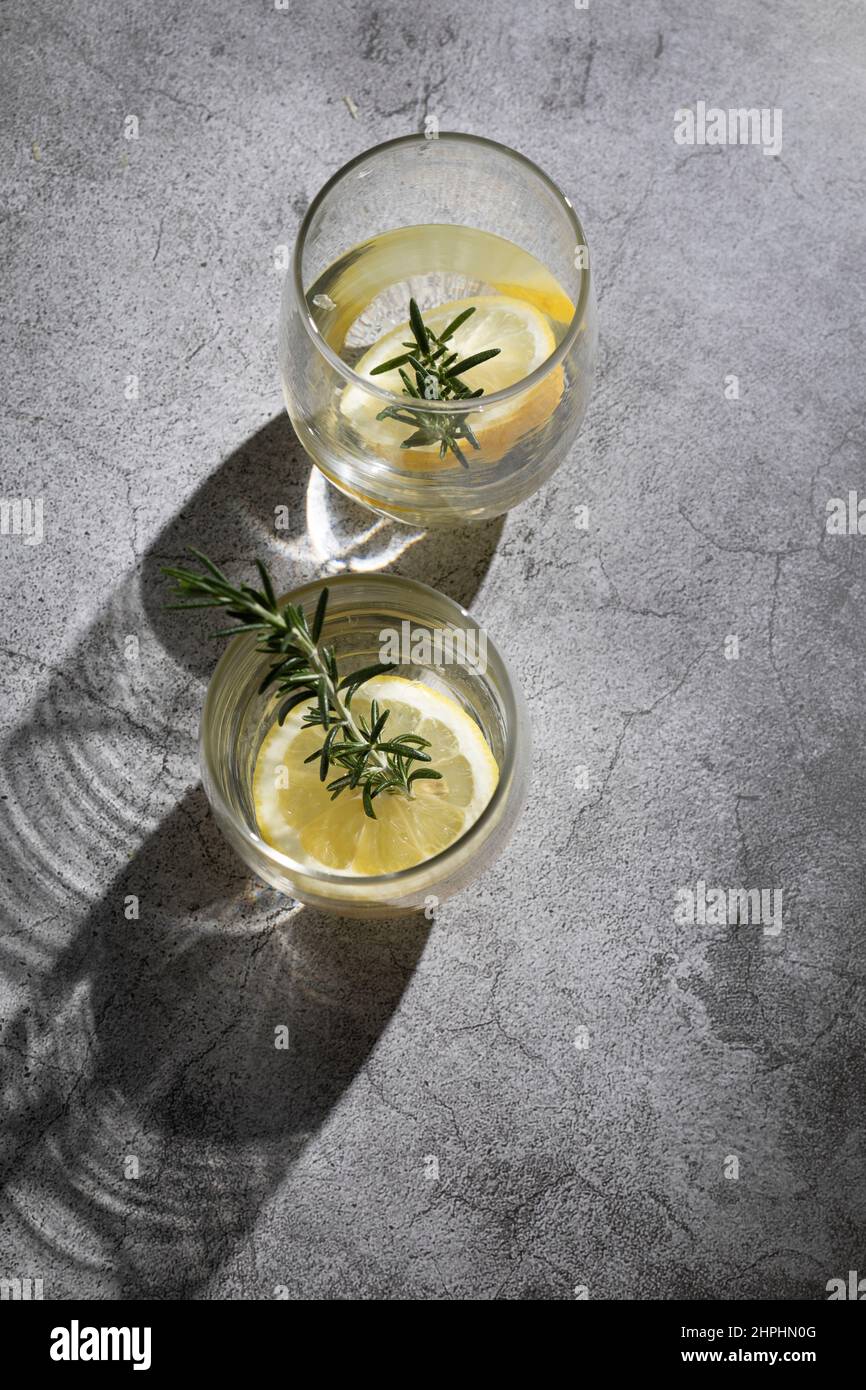 Bicchieri d'acqua con limone ed erbe aromatiche Foto Stock