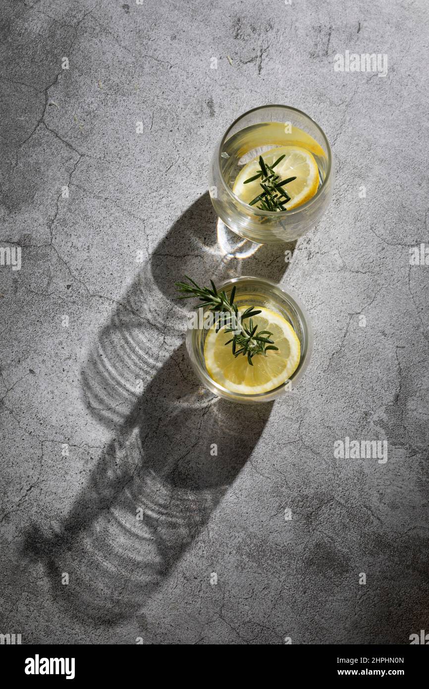Bicchieri d'acqua con limone ed erbe aromatiche Foto Stock